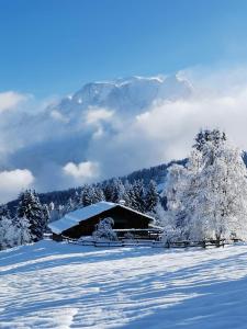 um celeiro coberto de neve em frente a uma montanha em Saint-Gervais-les-Bains, Appartement 4 personnes em Saint-Gervais-les-Bains