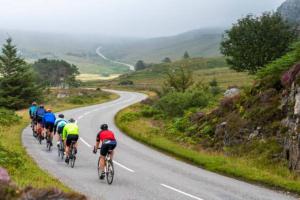 a group of people riding bikes down a road at The Stables in Pitlochry