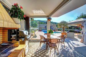 a patio with a table and chairs and a fireplace at The Love Villa in Kassiopi
