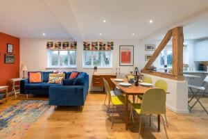 een woonkamer met een blauwe bank en een tafel bij The Granary, Cretingham in Woodbridge
