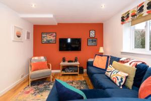 sala de estar con sofá azul y TV en The Granary, Cretingham en Woodbridge