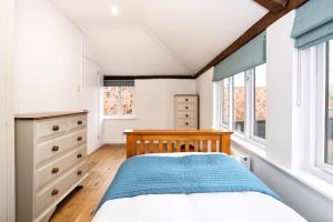 1 dormitorio con 1 cama y ventanas en The Granary, Cretingham en Woodbridge