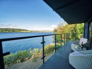 a balcony of a house with a view of the water at Tegid Lakeside - Bala Lake in Bala