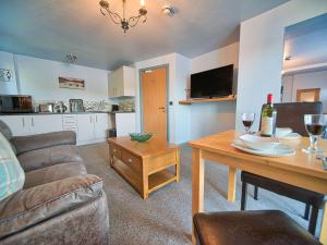 a living room with a couch and a table with wine glasses at Tegid Lakeside - Bala Lake in Bala