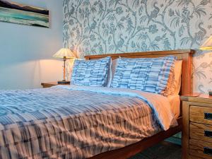 a bedroom with a bed with two blue pillows at Tegid Lakeside - Bala Lake in Bala