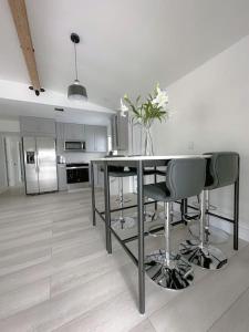 y cocina con mesa, sillas y nevera. en Dream House 4B/2B King Bed Miami Springs, FL en Miami