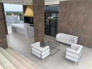 un soggiorno con 2 sedie bianche e un tavolo di Brickell - APARMENT 3G amplio y elegante a Santa Cruz de la Sierra