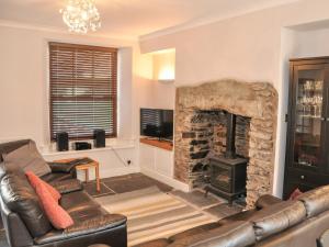 a living room with a couch and a fireplace at Old Stones Cottage in Ambleside