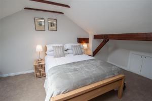 Old Stones Cottage في آمبيلسايد: غرفة نوم بسرير كبير في العلية