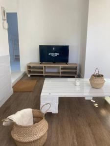 a living room with a television and a white table at Au bord de la Mayenne in Laval