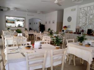 a restaurant with white tables and white chairs at B&b villa lambusta in Cesenatico