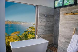 a bathroom with a tub and a large window at Tres Piedras in San Francisco Chinameca +75 photos