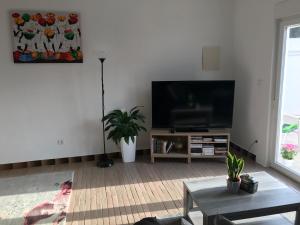 ein Wohnzimmer mit einem Flachbild-TV an der Wand in der Unterkunft Le Nid D’Abela in Abela