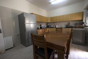 uma cozinha com uma mesa de madeira e um frigorífico de aço inoxidável em Ramallah Hostel em Ramallah