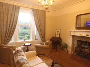 a living room with a couch and a fireplace at Abbeyfield B&B in Dufftown