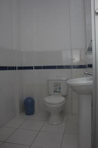 a white bathroom with a toilet and a sink at Posada Nueva España in Arequipa