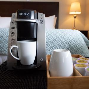 eine Kaffeemaschine und eine Tasse auf dem Tisch in einem Hotelzimmer in der Unterkunft The Water Street Inn in Ephraim