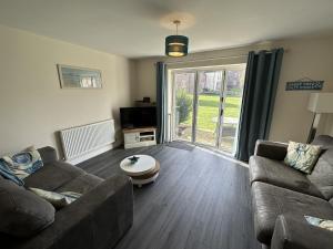 a living room with a couch and a coffee table at A Wave From It All - Part of the The Bay Filey Holiday Village with pool, gym and direct beach access, pub, restaurant, tennis and meadows walks in Filey