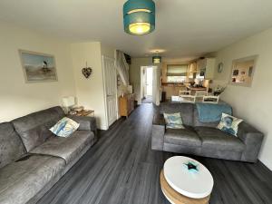 a living room with a couch and a table at A Wave From It All - Part of the The Bay Filey Holiday Village with pool, gym and direct beach access, pub, restaurant, tennis and meadows walks in Filey