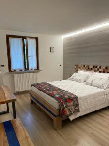 een slaapkamer met een groot bed met een houten hoofdeinde bij B&B Carmen in San Giovanni Bianco