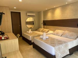a hotel room with two beds and a mirror at Cartagena Royal Hotel Boutique in Cartagena de Indias