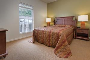 Un dormitorio con una cama grande y una ventana en WorldMark Lake of the Ozarks, en Osage Beach