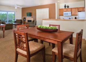 uma cozinha e sala de estar com uma mesa de madeira e cadeiras em WorldMark Lake of the Ozarks em Osage Beach