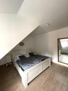 Schlafzimmer mit einem weißen Bett und einem Spiegel in der Unterkunft appartement - châtenois in Châtenois