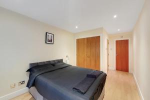 a bedroom with a large bed with blue sheets at Apartment in the heart of London in London