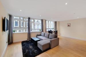 a living room with a couch and a large window at Apartment in the heart of London in London