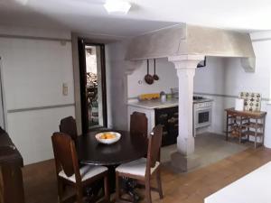 a dining room with a table and a kitchen with a stove at Casa Pontevella in Amés