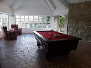 a room with a pool table in a room withwindows at Casa Pontevella in Amés