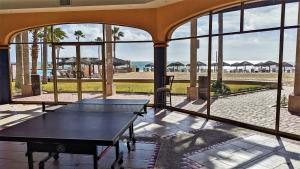 um quarto com uma mesa e vista para a praia em Princesa de Penasco B 208 em Puerto Peñasco