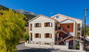 a building in a town with a mountain in the background at Alexatos Studios & Apartments in Ayia Evfimia