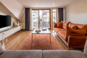 a living room with a brown couch and a table at BayMari Suites Plus Florya in Istanbul
