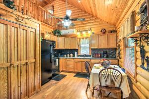 a kitchen with a table and a black refrigerator at Smoky Mountain Rustic Log Cabin with Furnished Patio in Cosby
