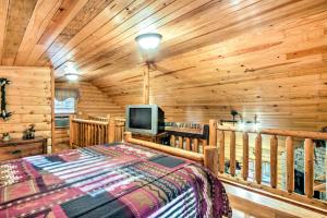 Cette cabane en rondins comprend un lit et une télévision. dans l'établissement Smoky Mountain Rustic Log Cabin with Furnished Patio, à Cosby