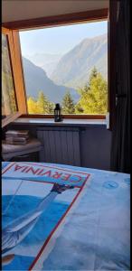 - une chambre avec une grande fenêtre offrant une vue sur la montagne dans l'établissement Maison Venera - Relax Appartaments in Valtournenche, à Valtournenche