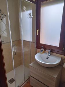 bagno con doccia in vetro e lavandino di O Pedregal a Burela de Cabo