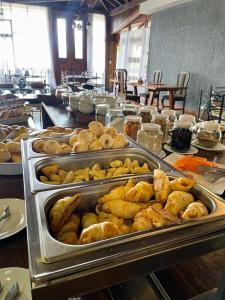 a buffet line with trays of bread and pastries at Pousada Lagos de Minas in Santa Cruz de Minas