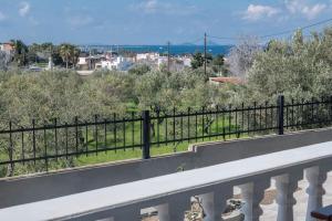 uma varanda com uma cerca e vista para a cidade em Kos Helios House em Psalidi