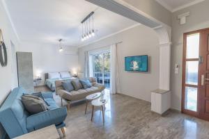 a living room with a blue couch and a bed at Kos Helios House in Psalidi