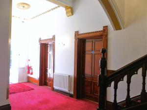 um corredor com uma escada e uma porta de madeira em Claremont Hotel em Nottingham