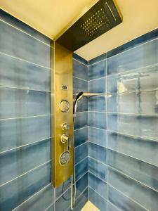 y baño con ducha de azulejos azules. en San Gregorio Luxury Apartments, en Nápoles
