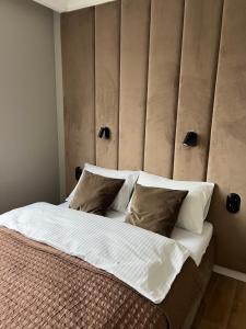 een slaapkamer met een groot bed met witte lakens en kussens bij Apartament Mokka Sopot in Sopot