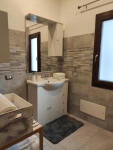 bagno con lavandino e specchio di Bidda Mores Appartamenti- Il Cacciatore a Capoterra