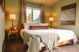 Un dormitorio con una cama grande y una ventana en Private Pool, Riverfront, Theater, Hot Tub, King Bed, Pets Welcome! en La Pine