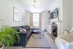uma sala de estar com um sofá preto e uma lareira em Southview Stays - Three bedroom House em Chester