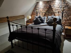 een slaapkamer met een zwart bed met kussens bij Hill View in Abertillery