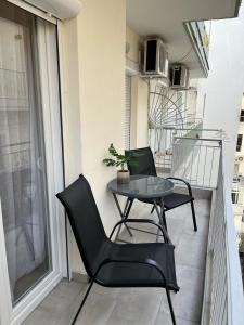 einen kleinen Balkon mit einem Tisch und Stühlen darauf in der Unterkunft Deluxe Arch of Galerius in Thessaloniki